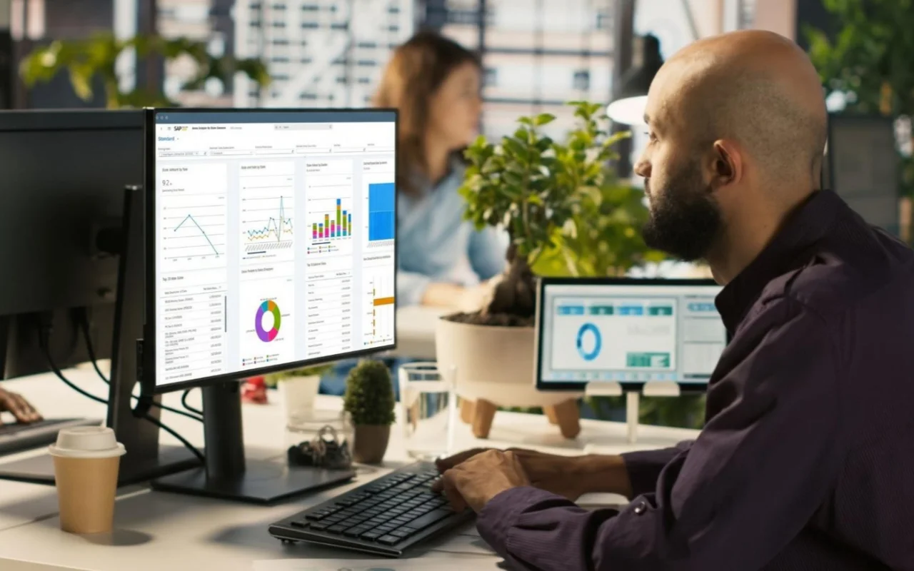 Homem trabalhando com análise de dados na tela da SAP em ambiente de escritório, ilustrando um conteúdo da Ramo sobre implementação de ERP.